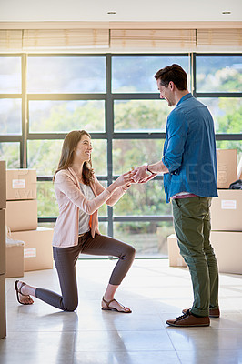 Buy stock photo Shot of a young woman proposing to her boyfriend while moving house