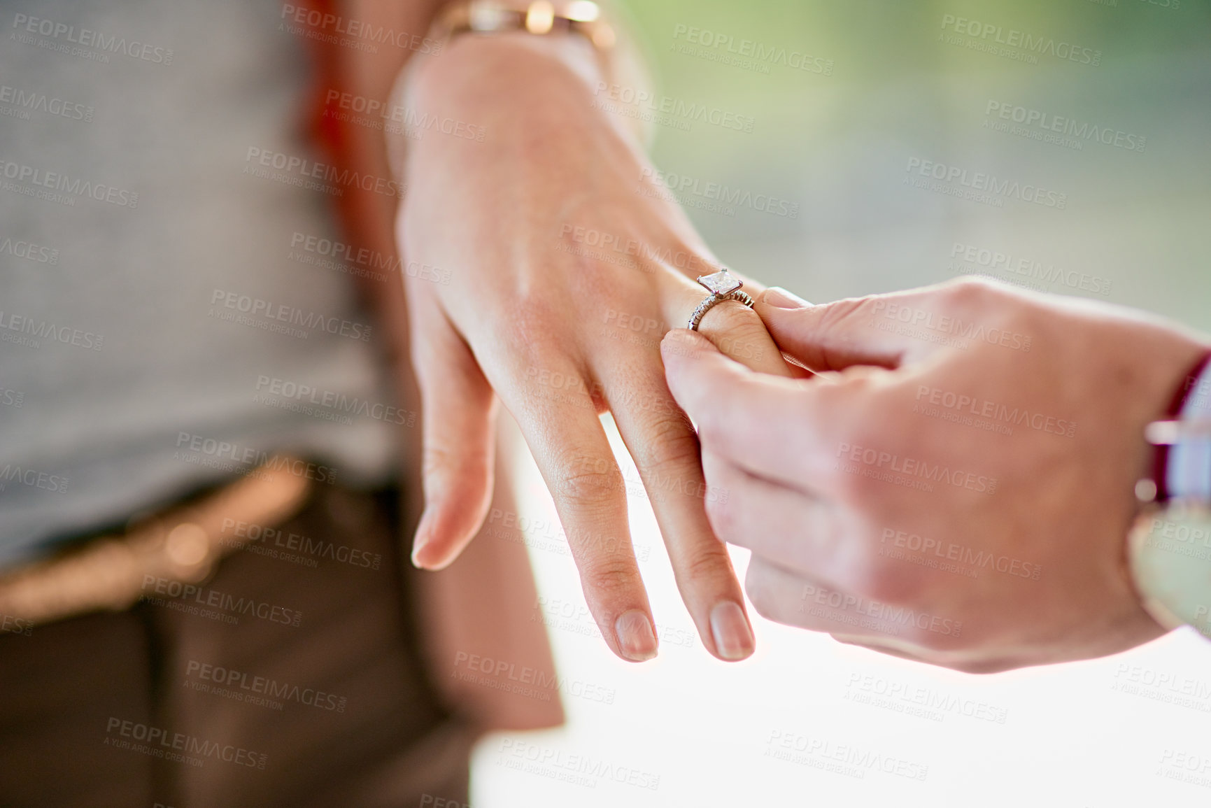 Buy stock photo Closeup shot of a man putting an engagement ring onto his fiancee’s finger