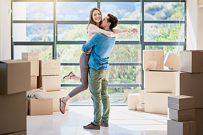 Buy stock photo Shot of a young couple celebrating their move into a new home