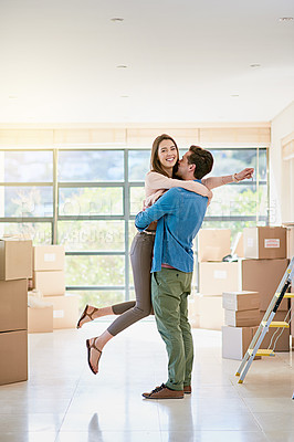 Buy stock photo Shot of a young couple celebrating their move into a new home
