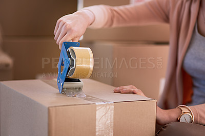 Buy stock photo Cropped shot of an unidentifiable woman packing boxes while moving house