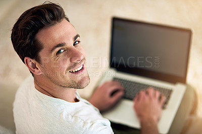 Buy stock photo Portrait of a happy young man using a laptop on the sofa at home