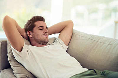 Buy stock photo Shot of a young man relaxing on the sofa at home