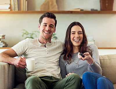 Buy stock photo Portrait of a happy young couple relaxing on the sofa and watching tv together