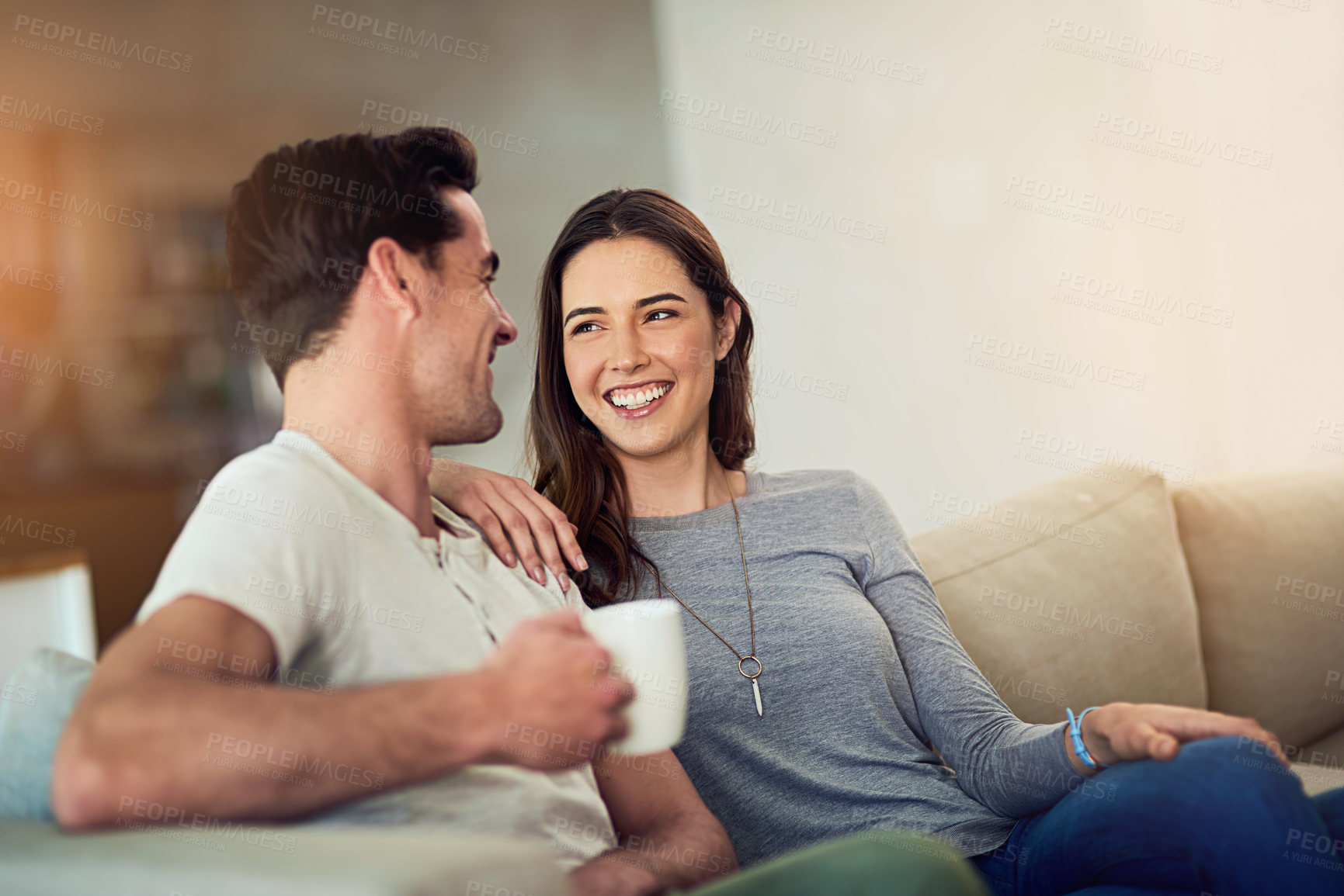 Buy stock photo Shot of a happy young couple relaxing together at home