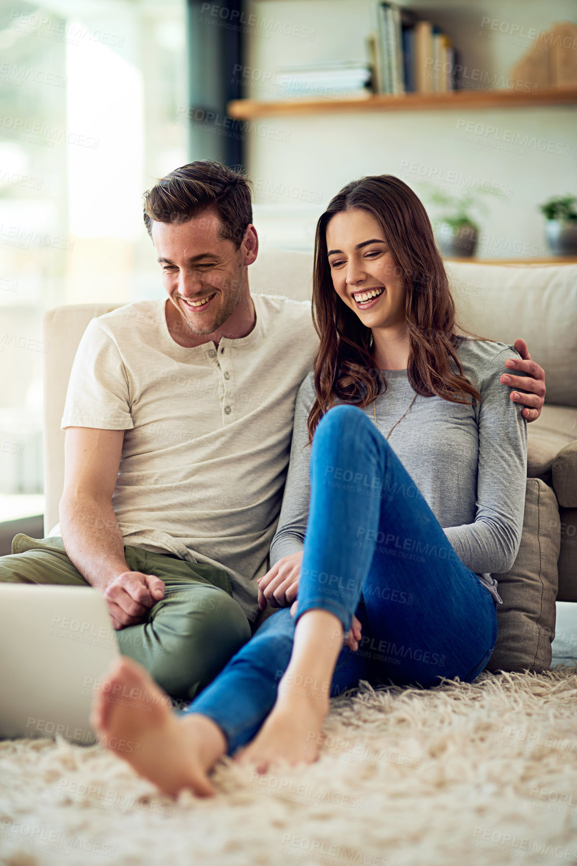 Buy stock photo Shot of a relaxed young couple using a laptop together at home