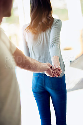 Buy stock photo Shot of a young woman holding her boyfriend’s hand and leading the way
