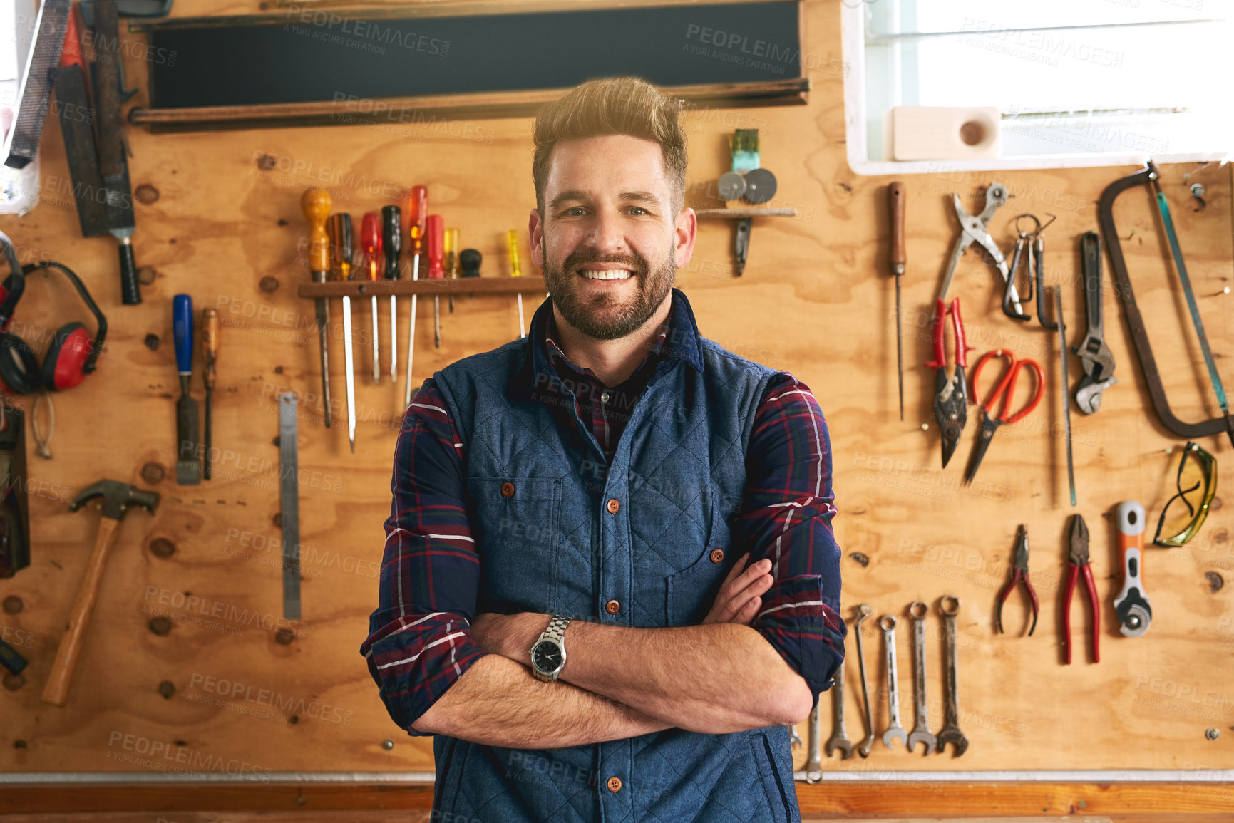 Buy stock photo Handyman, portrait and smile in workshop for career with tools, renovation or maintenance services. Male contractor, wood workbench and happiness for job in construction, home project or repair work