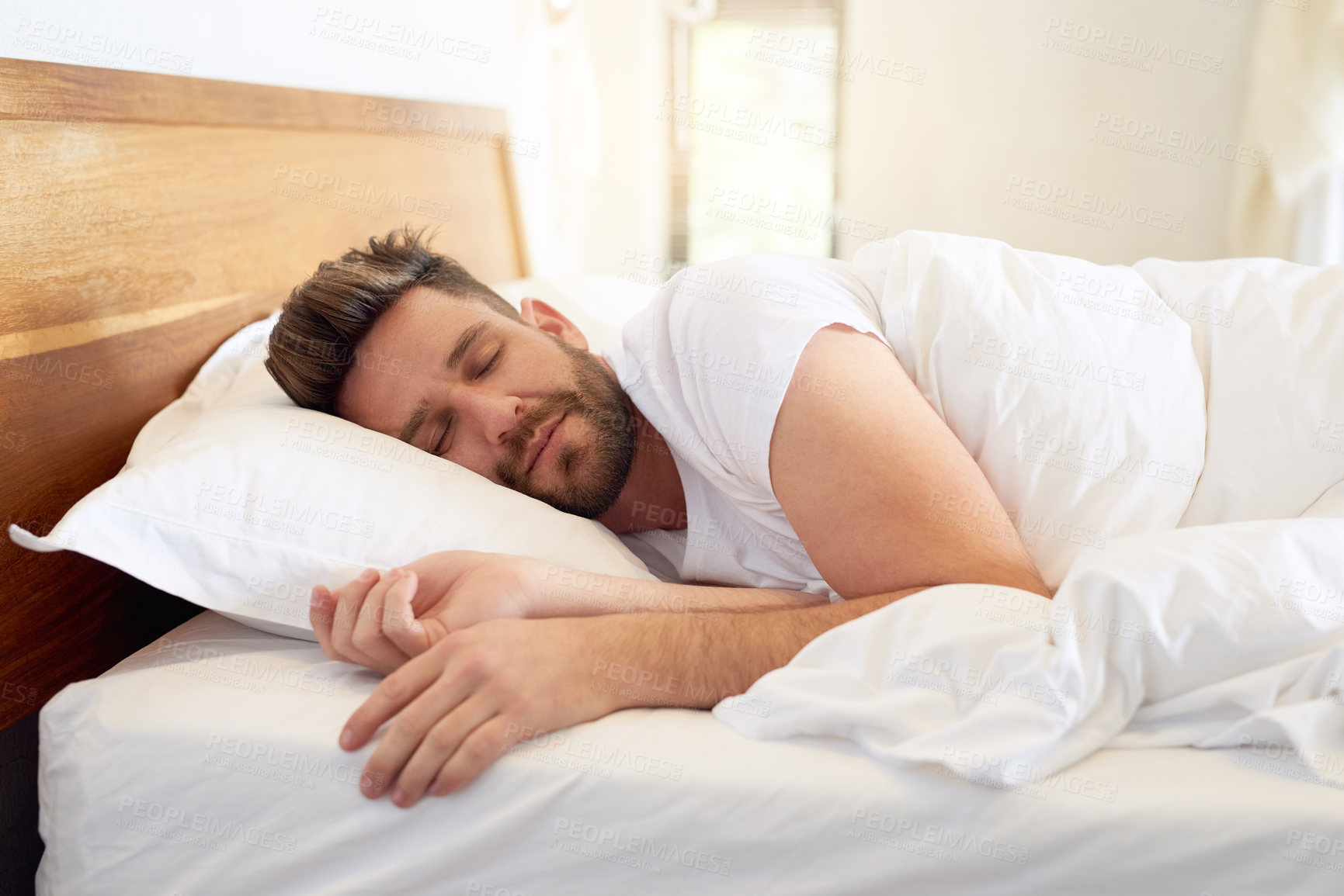 Buy stock photo Cropped shot of a young man sleeping peacefully in bed at home
