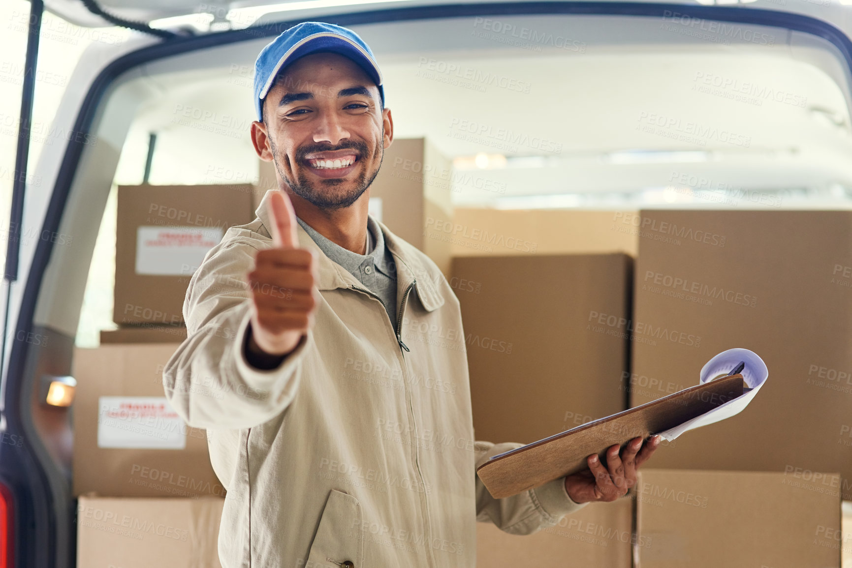Buy stock photo Cropped portrait of a handsome young delivery man checking his orders for the day