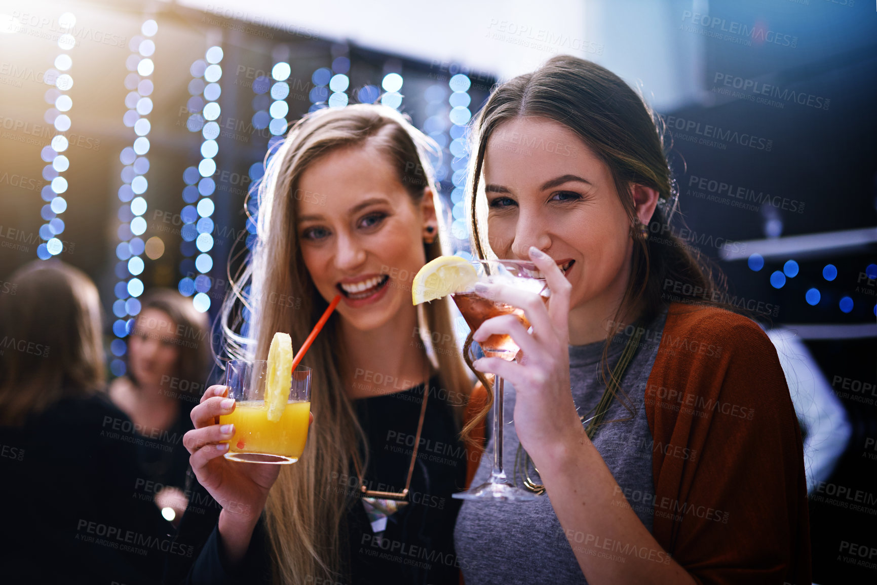Buy stock photo Portrait of two young friends having drinks together at a party