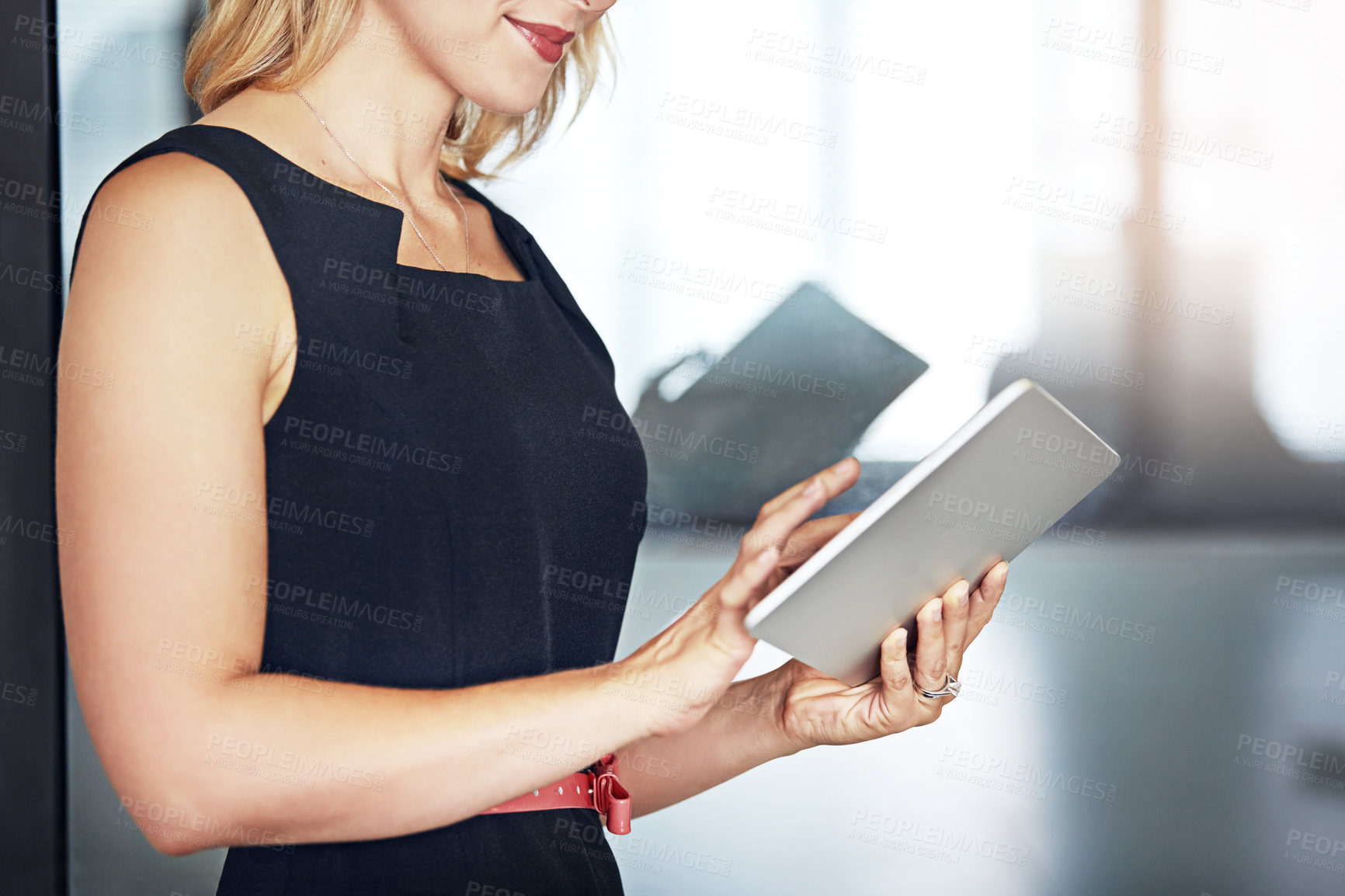 Buy stock photo Shot of an unidentifiable businesswoman using a tablet in the office