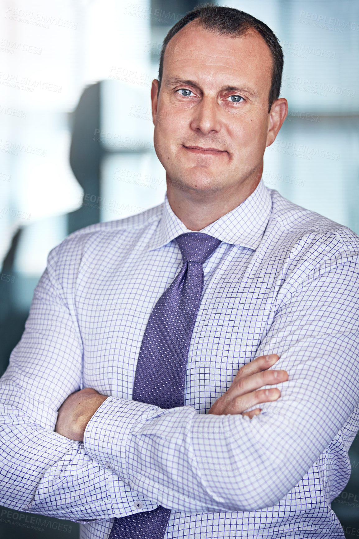 Buy stock photo Cropped portrait of a well dressed businessman posing with his arms crossed