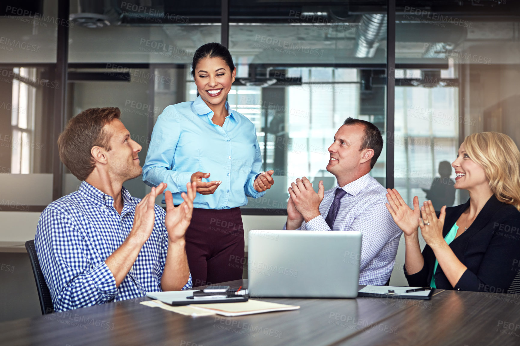 Buy stock photo Shot of a group of colleagues applauding their colleague during a meeting at work