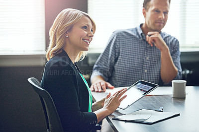 Buy stock photo Shot of a businesswoman using a digital tablet during a meeting at work