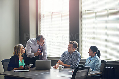 Buy stock photo Shot of a group of colleagues having a meeting in the boardroom at work