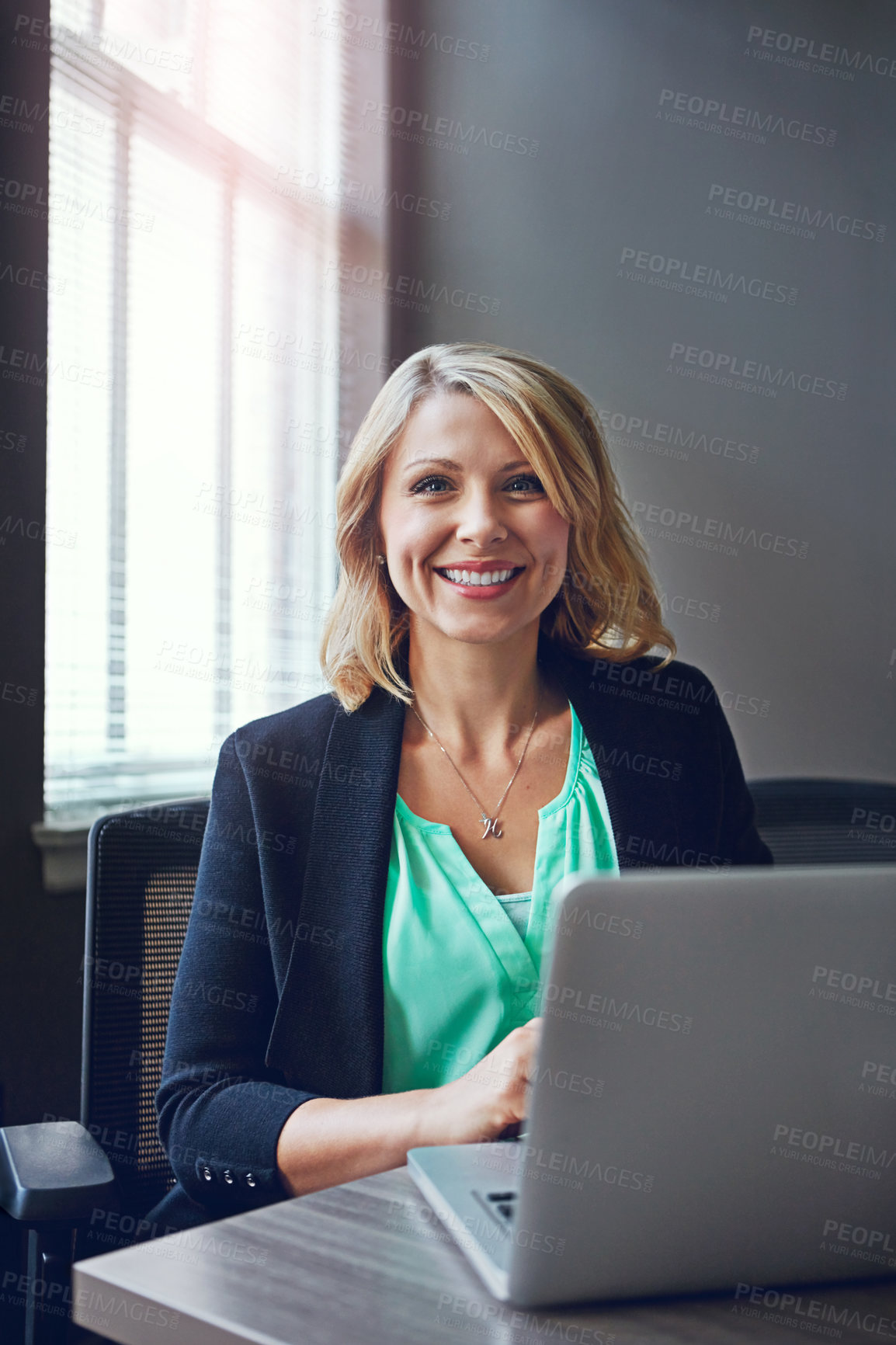 Buy stock photo Portrait of a happy businesswoman using her laptop in the office