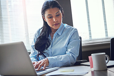 Buy stock photo Shot of an attractive businesswoman using her laptop in the office