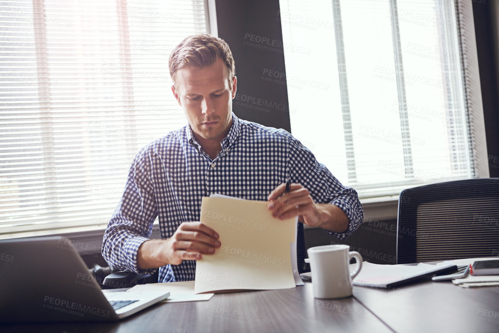 Buy stock photo Shot of a busy businessman using his laptop in the office