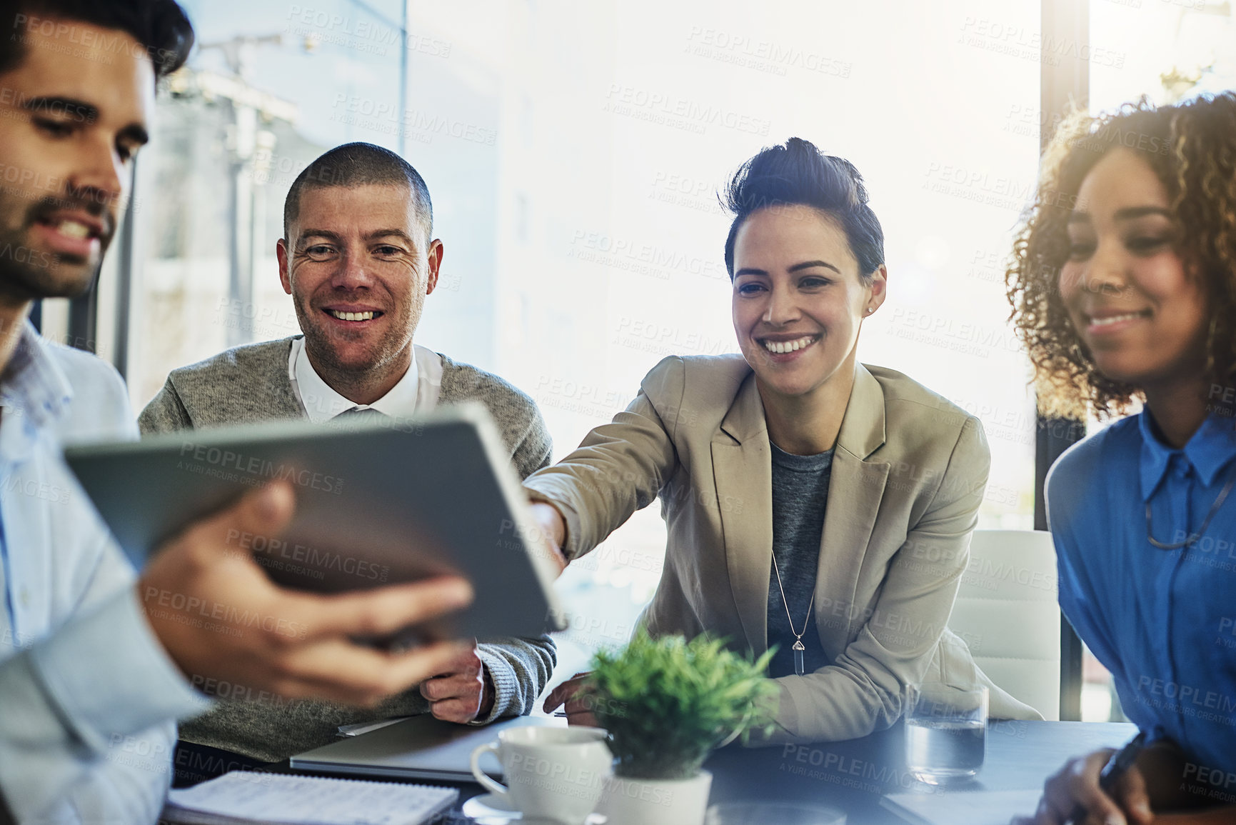 Buy stock photo Shot of a group of colleagues using a tablet while meeting in the boardroom