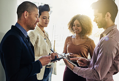 Buy stock photo Shot of a group of colleagues using a tablet while meeting in the boardroom