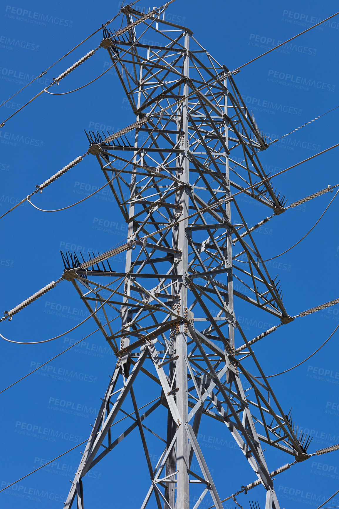 Buy stock photo Blue sky, cable and power with electricity pylon outdoor from below for generation or supply. Frame, metal or steel and infrastructure with transfer of high voltage current on grid for consumption