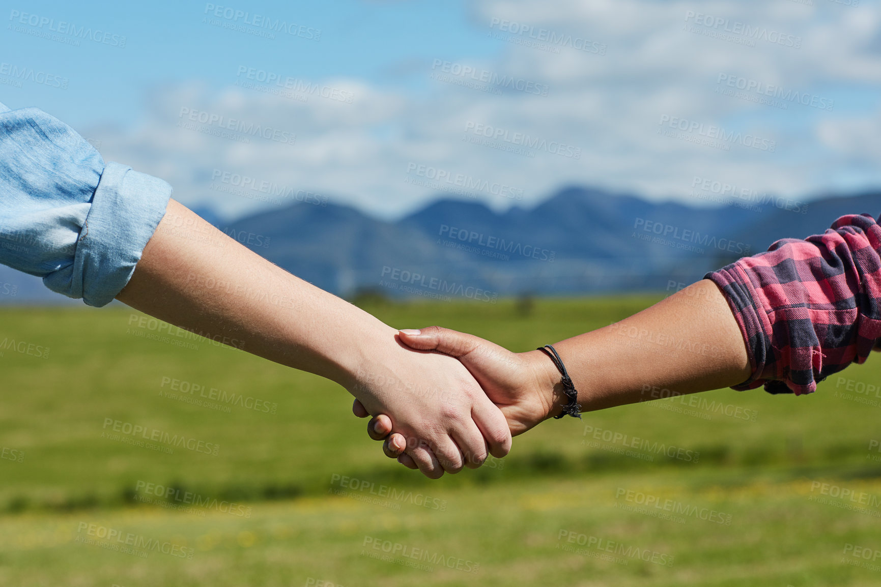 Buy stock photo Field, arms and holding hands in nature for support, direction and guidance on grass. People, couple and handshake outdoors for help, assistance and trust in relationship or agriculture deal