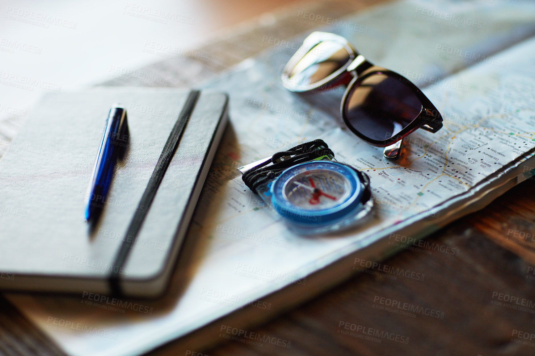 Buy stock photo Shot of a map and adventure gear arranged on a table