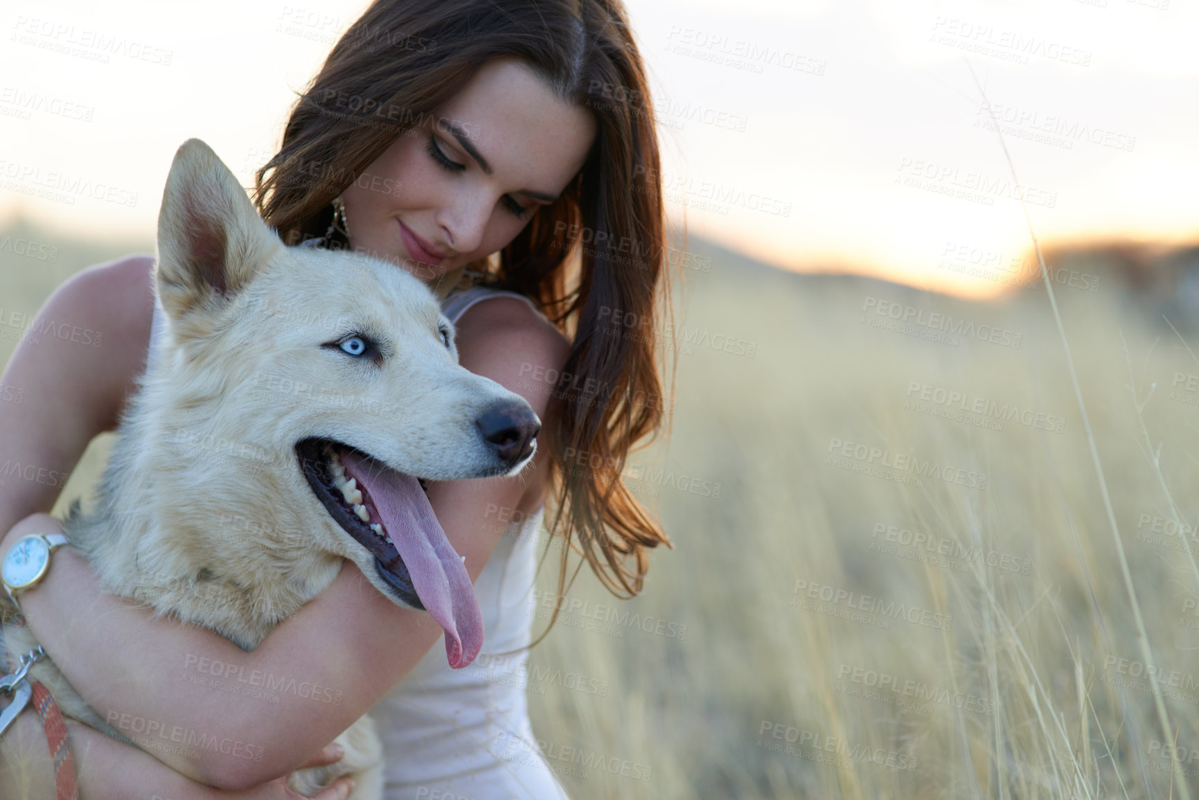 Buy stock photo Shot of an attractive young woman bonding with her dog outdoors