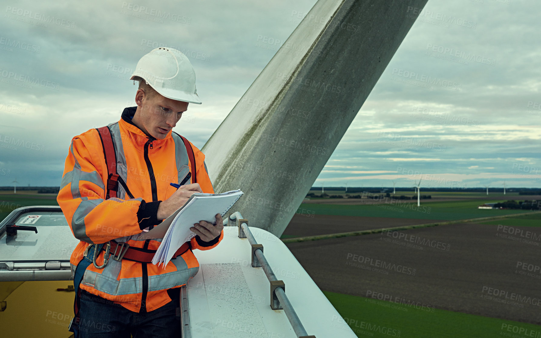 Buy stock photo Wind turbine, inspection and man in electricity maintenance for outdoor industrial grid with checklist. Renewable energy, quality assurance and technician with paperwork at electrical windmill field.