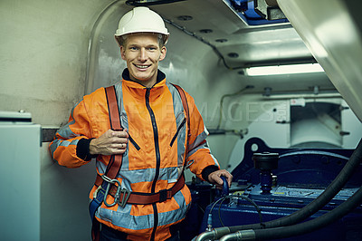Buy stock photo Portrait of a young engineer working with complicated machinery while wearing safety gear