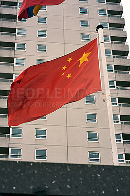 Buy stock photo Buildings, wind and flag of China on pole for country, congress and national banner of identity. Material, color and state fabric with wave for architecture, politics and symbol of government