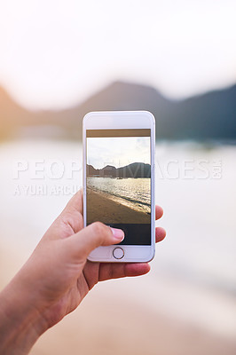 Buy stock photo Cropped shot of a young woman taking photographs at the beach