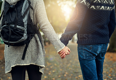 Buy stock photo Rearview shot of a couple holding hands while walking through a foreign city