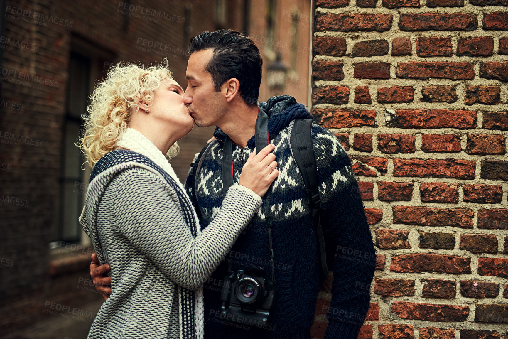 Buy stock photo Cropped shot of an affectionate young couple kissing while on vacation