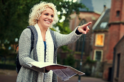 Buy stock photo Cropped shot of a young woman looking at a map while on vacation