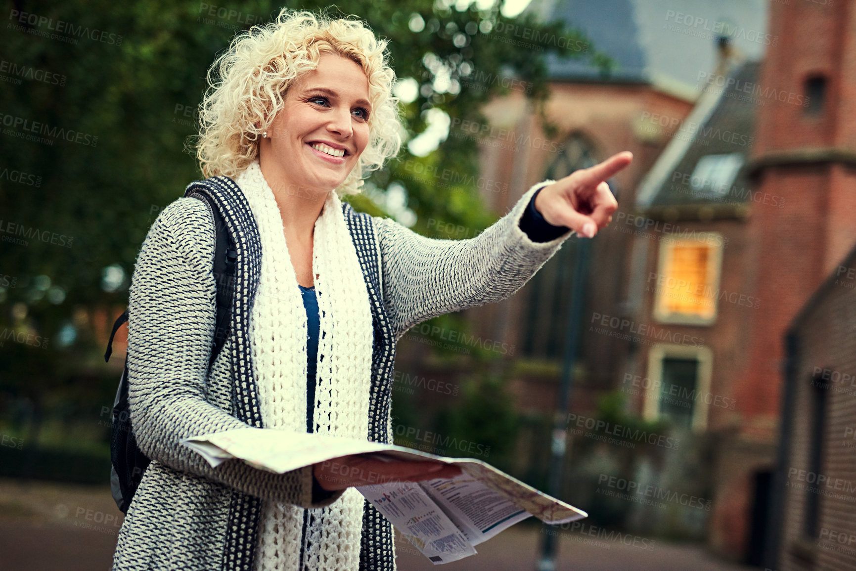 Buy stock photo Cropped shot of a young woman looking at a map while on vacation