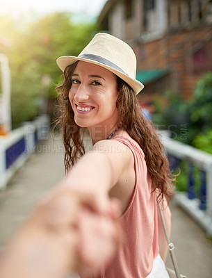 Buy stock photo Portrait of a young woman on holiday leading her unidentifiable boyfriend by the hand