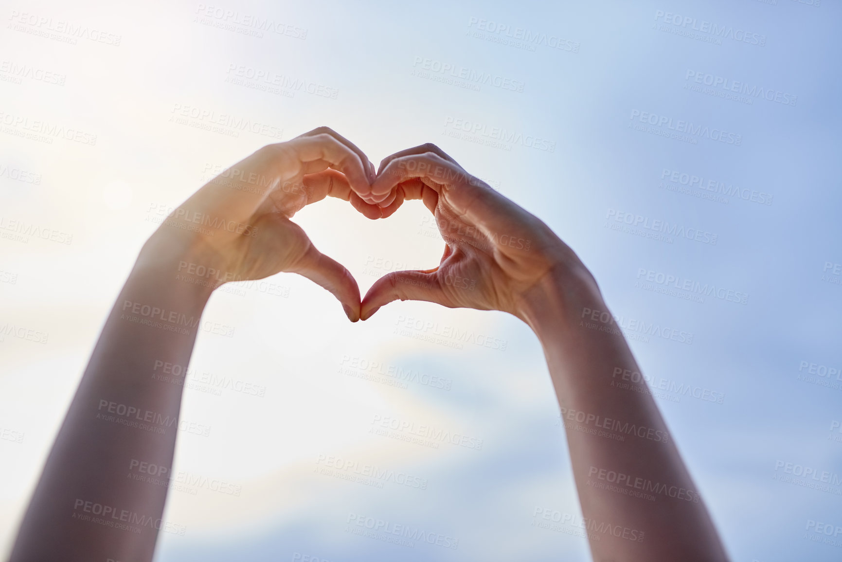 Buy stock photo Cropped shot of hands making a heart shape against a blue sky