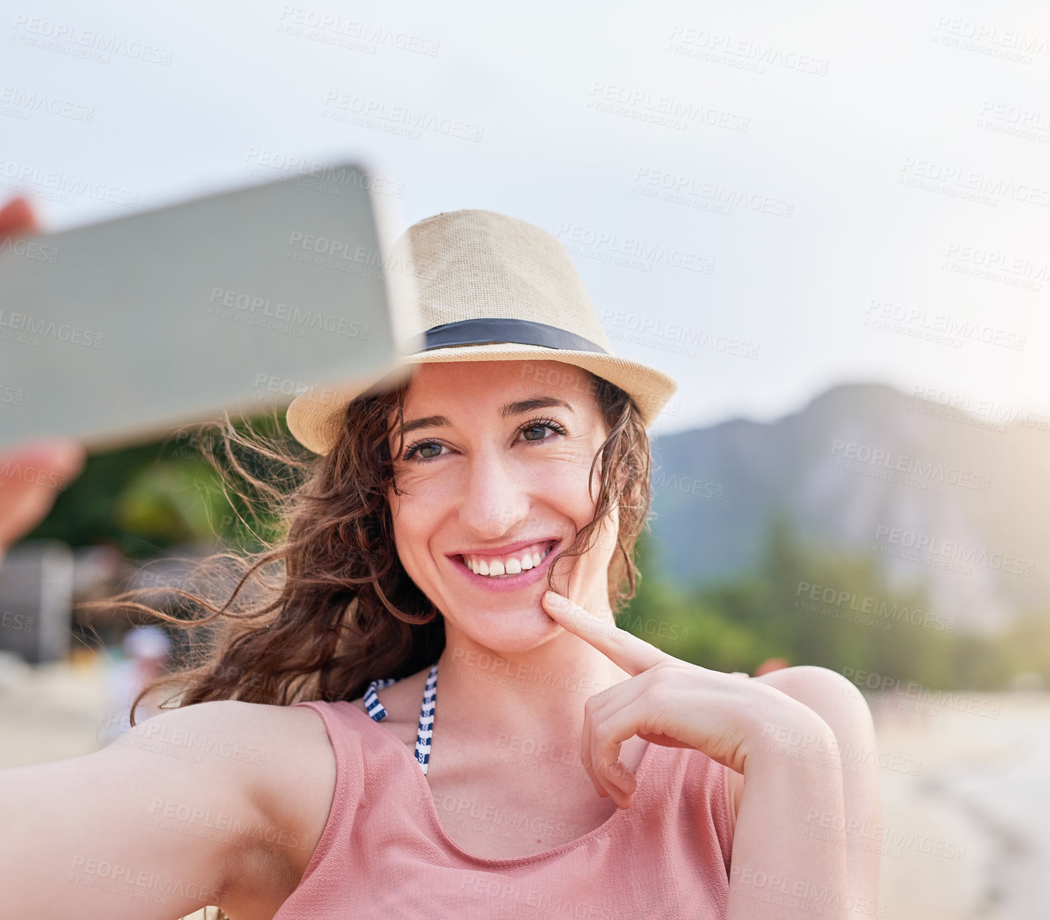 Buy stock photo Shot of a happy young woman taking a selfie with her phone on a tropical beach