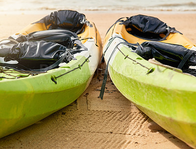 Buy stock photo Shot of two empty canoes arranged on a beach