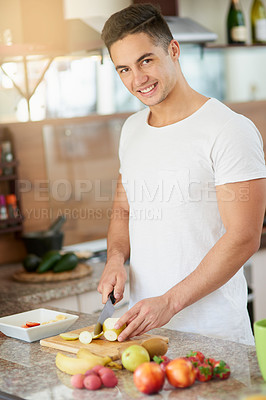 Buy stock photo Cropped shot of a young man making a fruit salad in his kitchen