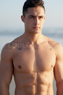 Buy stock photo Cropped shot of a handsome young man standing shirtless at the beach