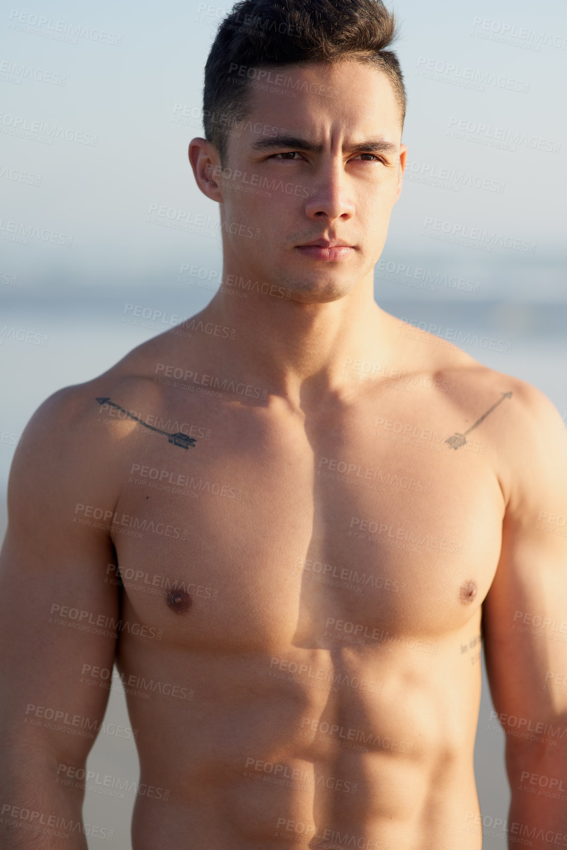 Buy stock photo Cropped shot of a handsome young man standing shirtless at the beach
