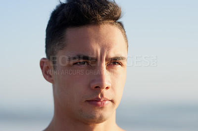 Buy stock photo Cropped shot of a handsome young man at the beach
