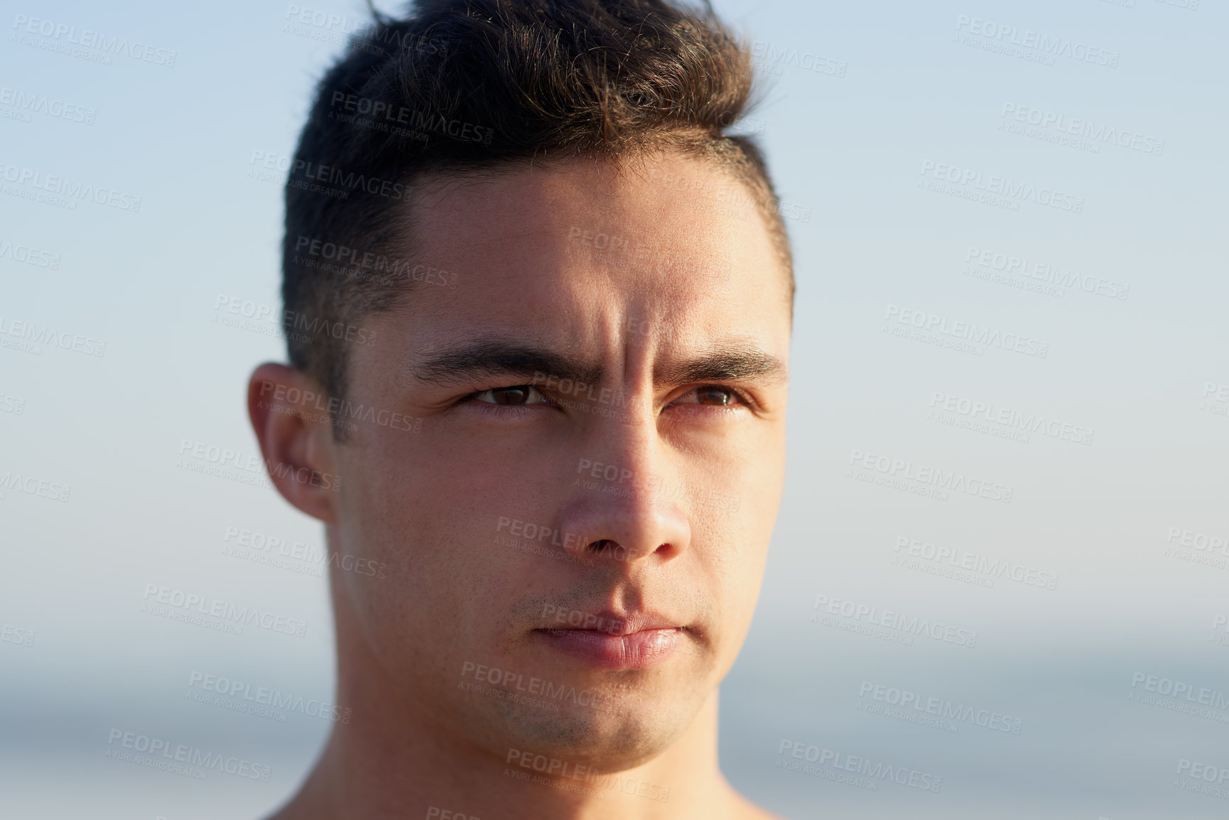 Buy stock photo Cropped shot of a handsome young man at the beach