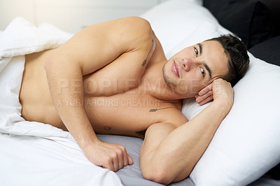 Buy stock photo Cropped shot of a handsome young man lying in bed