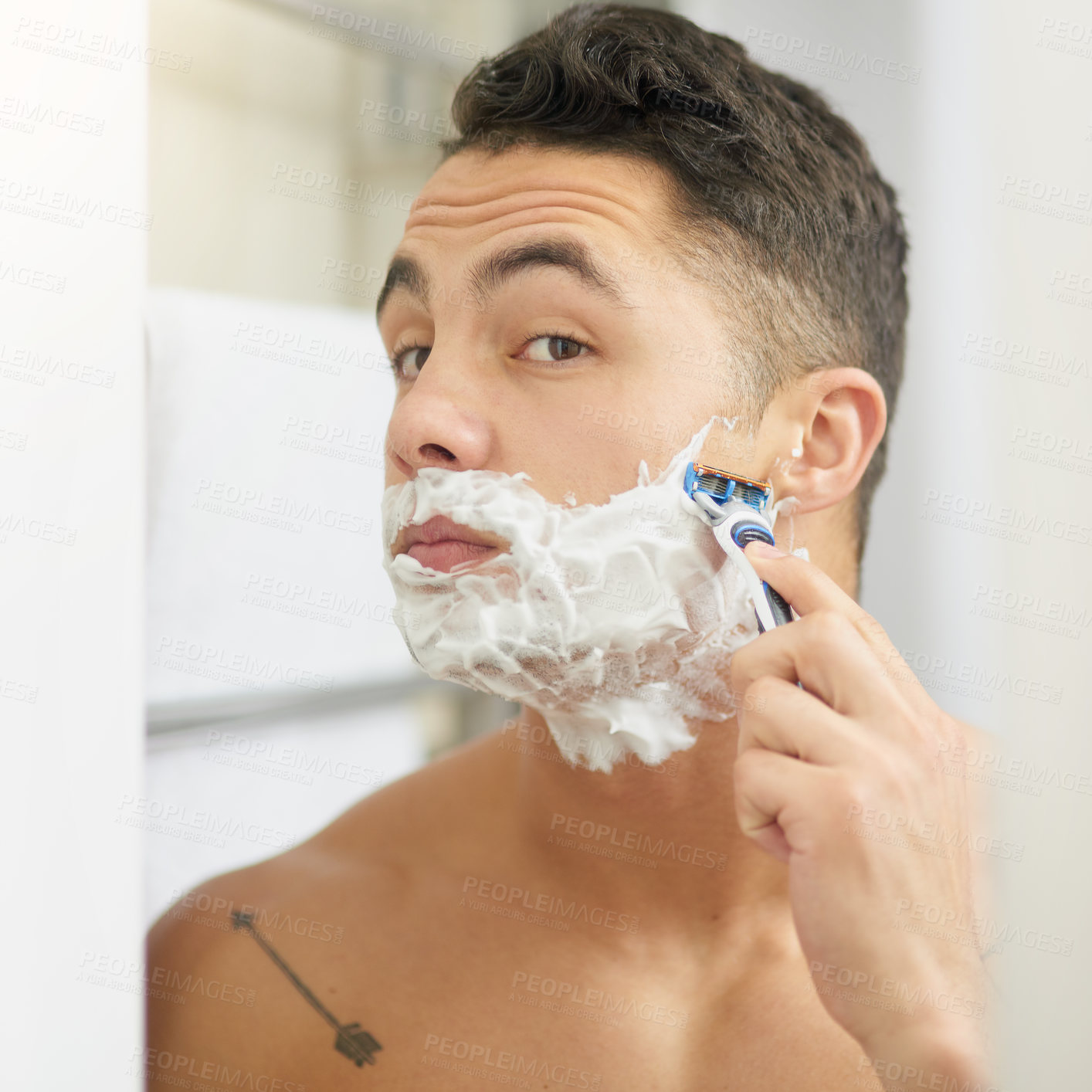 Buy stock photo Cropped shot of a young man shaving his beard