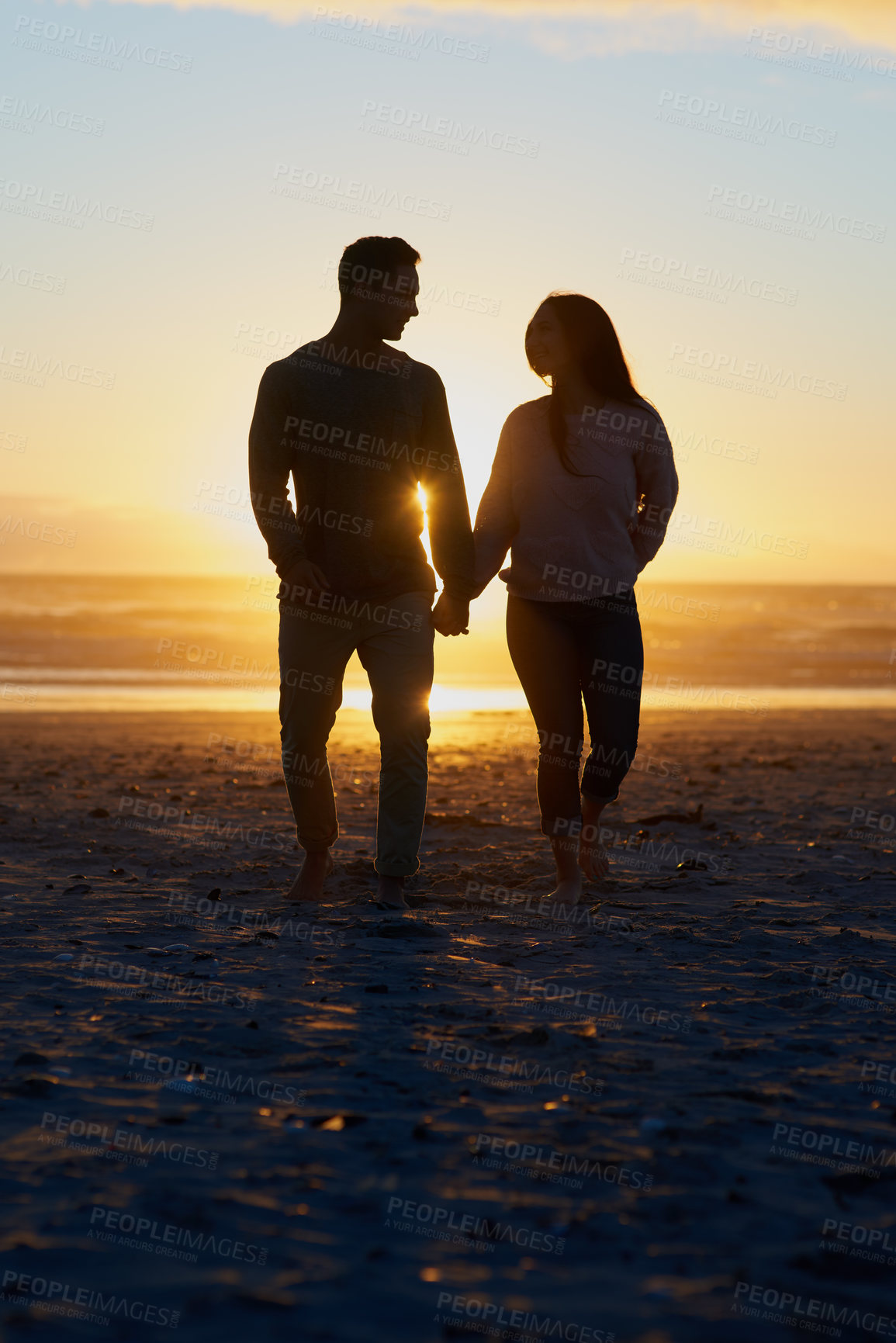 Buy stock photo Sunset, silhouette and couple on beach holding hands for romance, bonding and tropical holiday in Bali. Love, man and woman with waves, ocean and support on evening vacation together for honeymoon