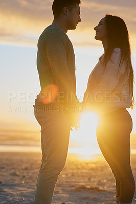 Buy stock photo Shot of a young couple at the beach at sunset